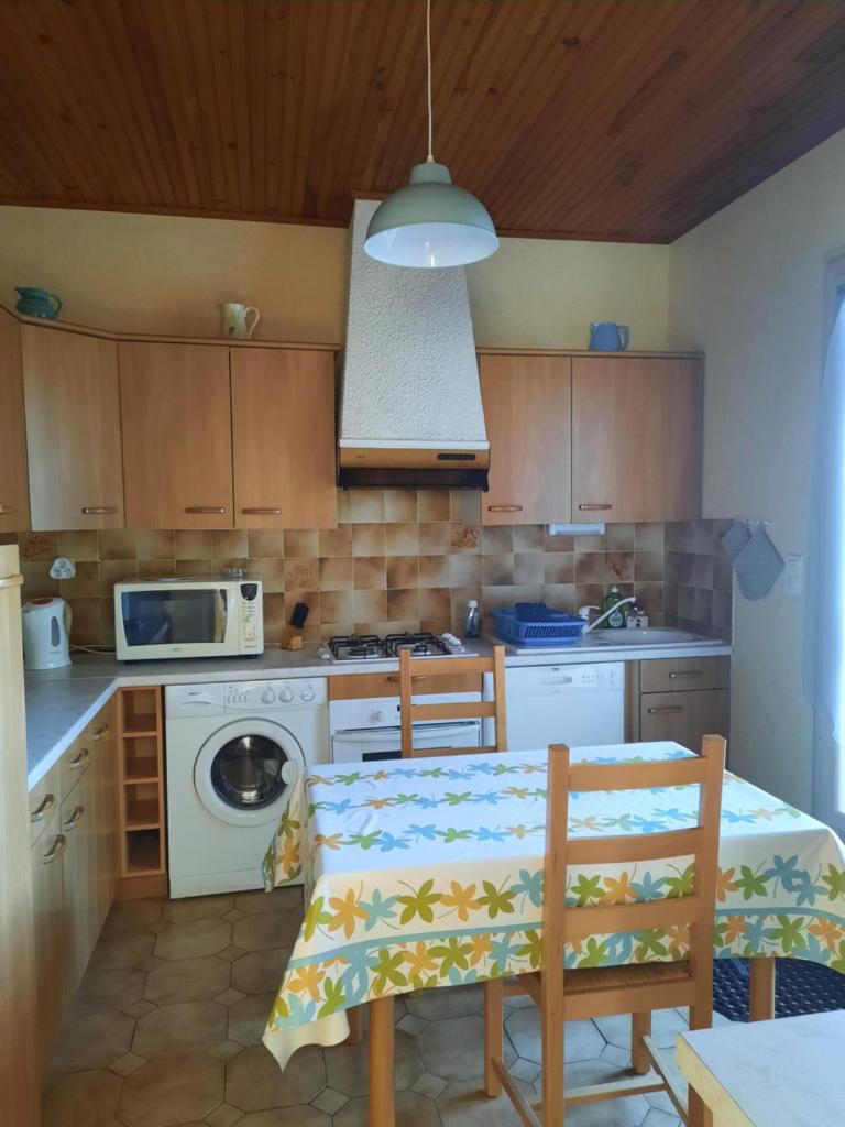 Il comprend une cuisine équipée d'une table, d'une cuisinière et d'un four micro-ondes. dans l'établissement Gite de La Cheneraie, à Montpezat-de-Quercy
