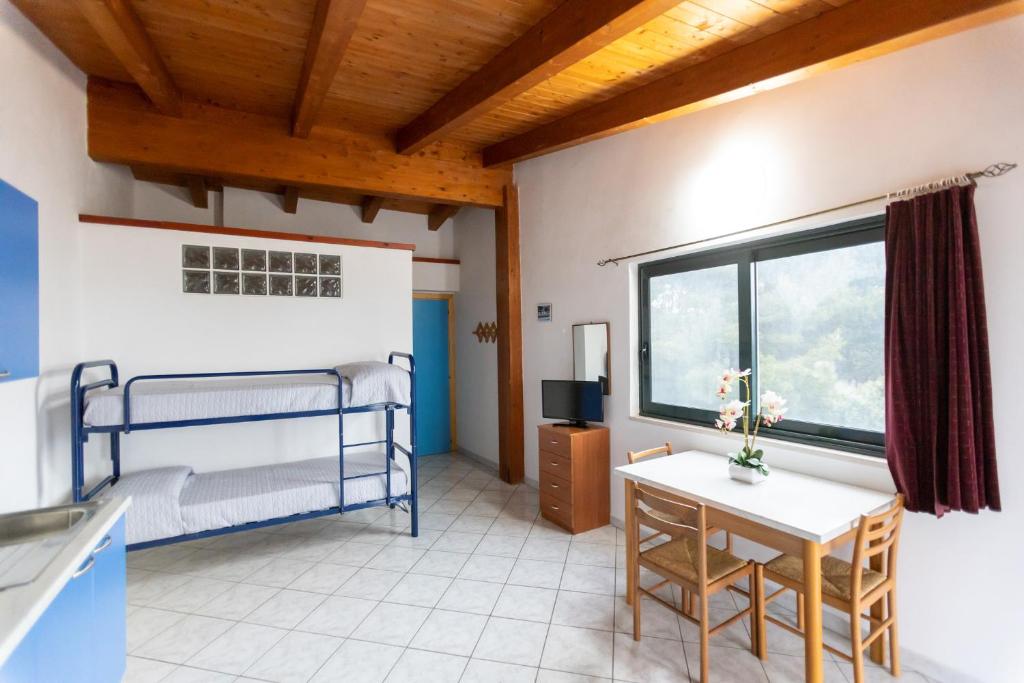 une chambre avec un lit superposé et une table dans l'établissement RESIDENCE EMARINE con SERVIZIO SPIAGGIA INCLUSO, à Peschici