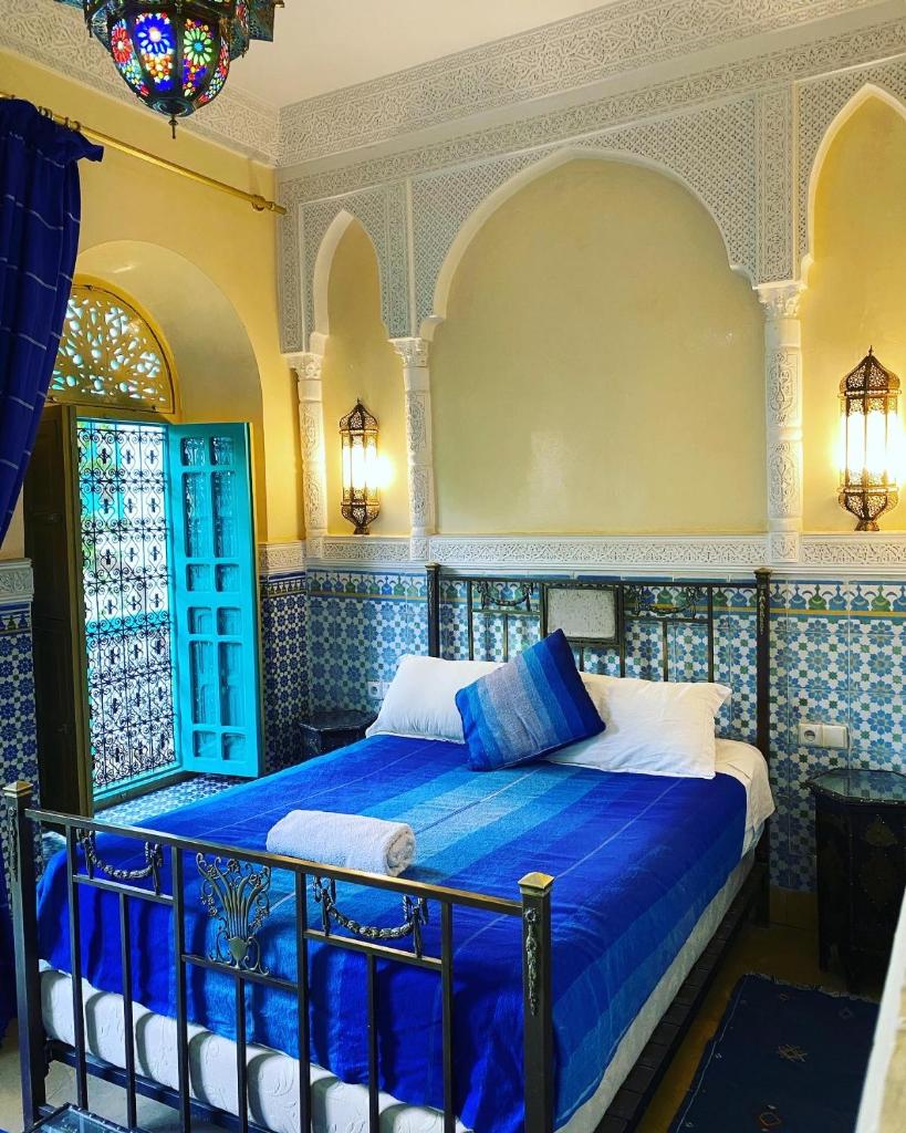 - une chambre avec un lit bleu dans l'établissement Riad Al Nour, à Marrakech