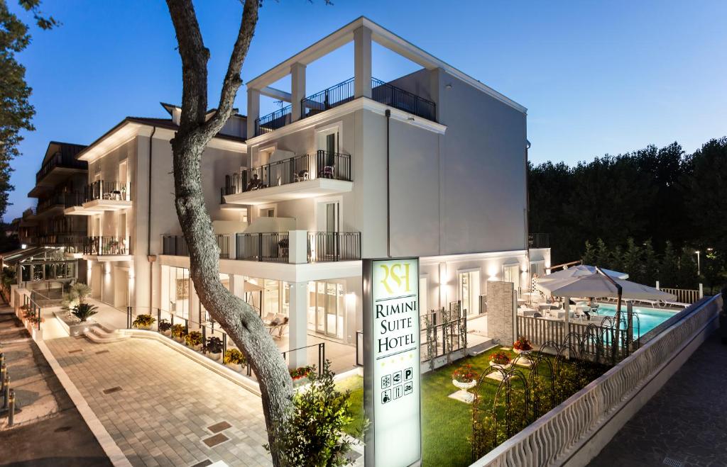 un bâtiment blanc avec un panneau devant dans l'établissement Rimini Suite Hotel, à Rimini