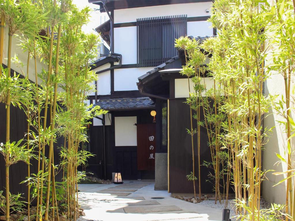 une cour avec des bambous devant un bâtiment dans l'établissement Ryokan Tanoya, à Kyoto