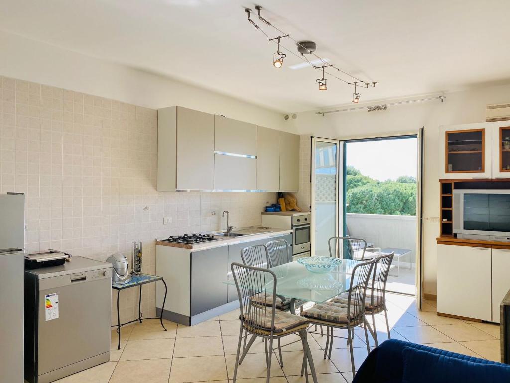 une cuisine avec une table et des chaises dans une cuisine dans l'établissement Residenza Arene, à Gallipoli