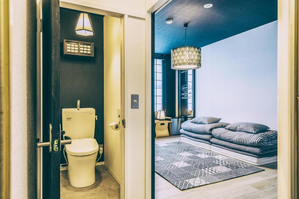 une salle de bain avec toilettes et un lit dedans dans l'établissement Ogawa Ryokan, à Shimoda