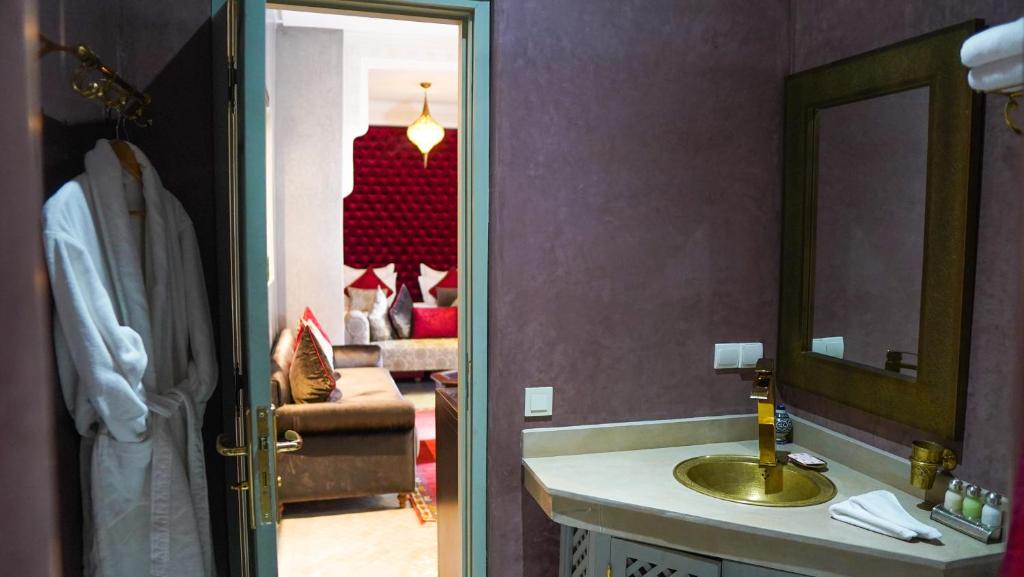 une salle de bain avec un lavabo, un miroir et un canapé dans l'établissement Riad Sultan Suleiman, à Marrakech 37 autres photos
