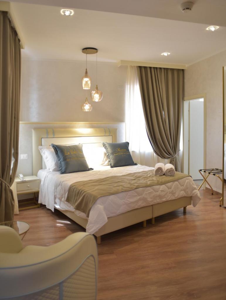 une chambre avec un grand lit dans une pièce dans l'établissement Amsterdam Suite Hotel & SPA, à Rimini