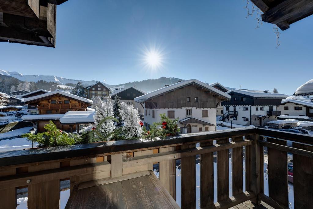 Elle comprend un balcon offrant une vue sur un village enneigé. dans l'établissement Hôtel La Grange d'Arly, à Megève