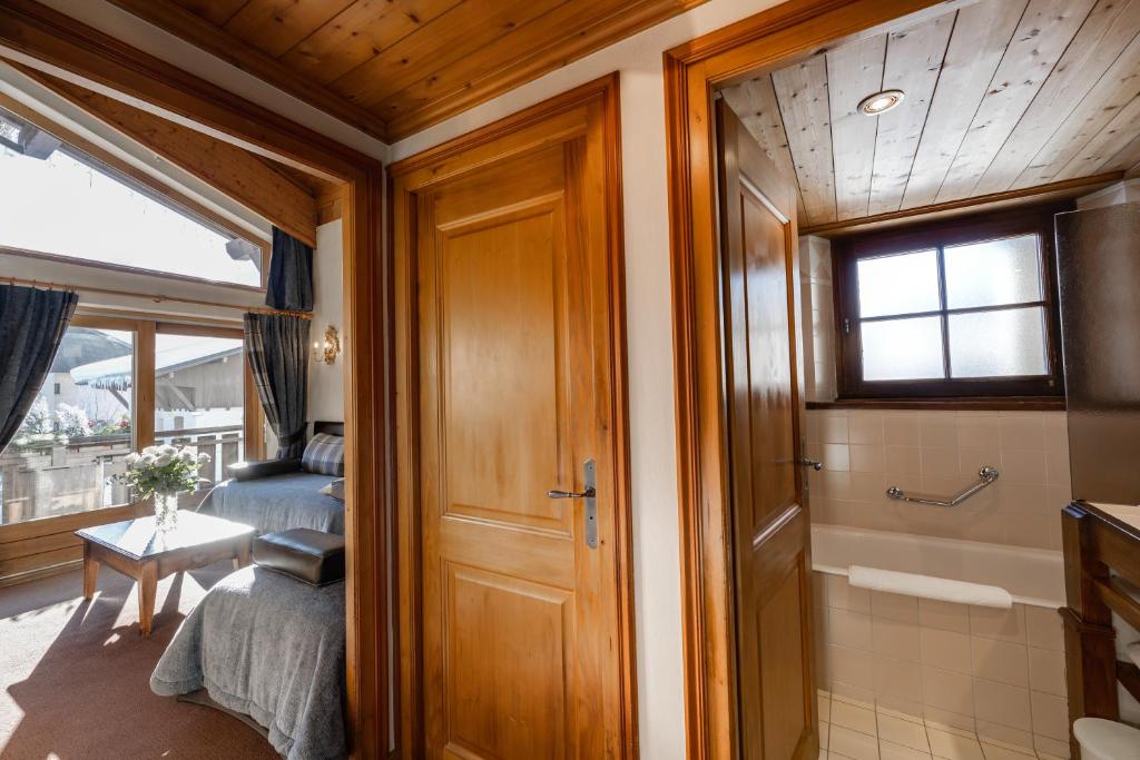 Cette chambre comprend un lit et une salle de bains pourvue d'une douche. dans l'établissement Hôtel La Grange d'Arly, à Megève