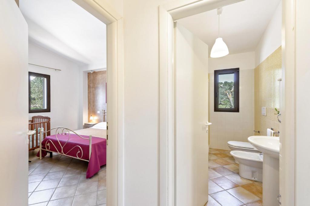 une salle de bains et une chambre avec un lit et un lavabo. dans l'établissement Villa Käthe con Piscina Privata, à San Vito dei Normanni
