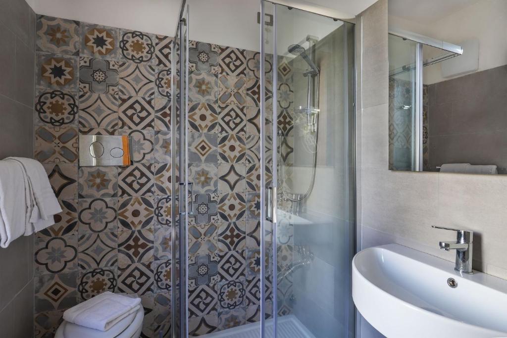 une salle de bain avec une douche, des toilettes et un lavabo dans l'établissement Hotel Nuovo Tirreno, à Lido di Camaiore