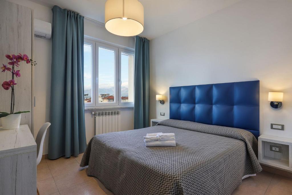 une chambre avec un lit bleu et une fenêtre dans l'établissement Hotel Nuovo Tirreno, à Lido di Camaiore