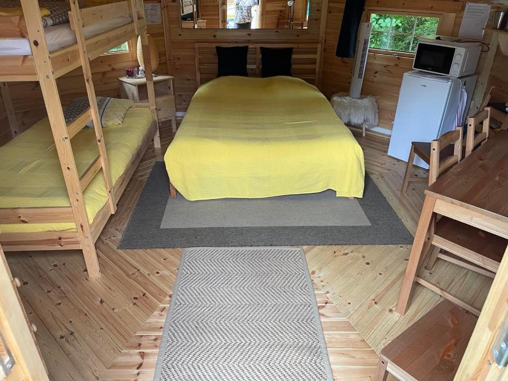 une chambre avec un lit avec une couverture jaune dans l'établissement Kota à la ferme, à Beaumont-en-Argonne