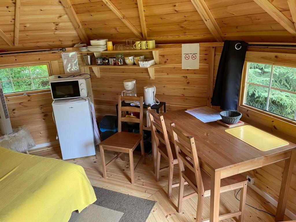 - une cuisine et une salle à manger dans une cabane en rondins dans l'établissement Kota à la ferme, à Beaumont-en-Argonne