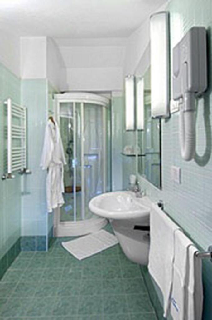 une salle de bain avec un lavabo, des toilettes et une douche dans l'établissement Hotel Souvenir, à Lido di Savio