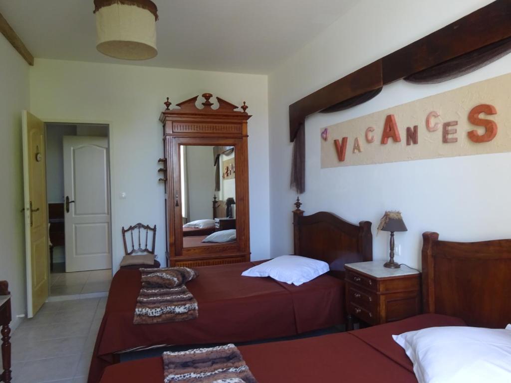une chambre avec deux lits et un miroir dans l'établissement Gîtes "tout au sud de la France", à Pomérols 37 autres photos