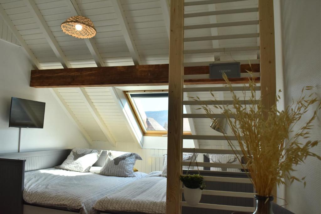 - une chambre avec une mezzanine et une fenêtre dans l'établissement Charmant studio, le petit gris des montagnes, à Mouthe