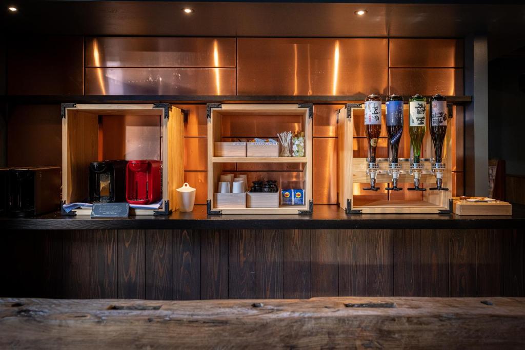 - un bar avec un comptoir muni de bouteilles d'alcool dans l'établissement Ryokan Nushiya, à Gotsu