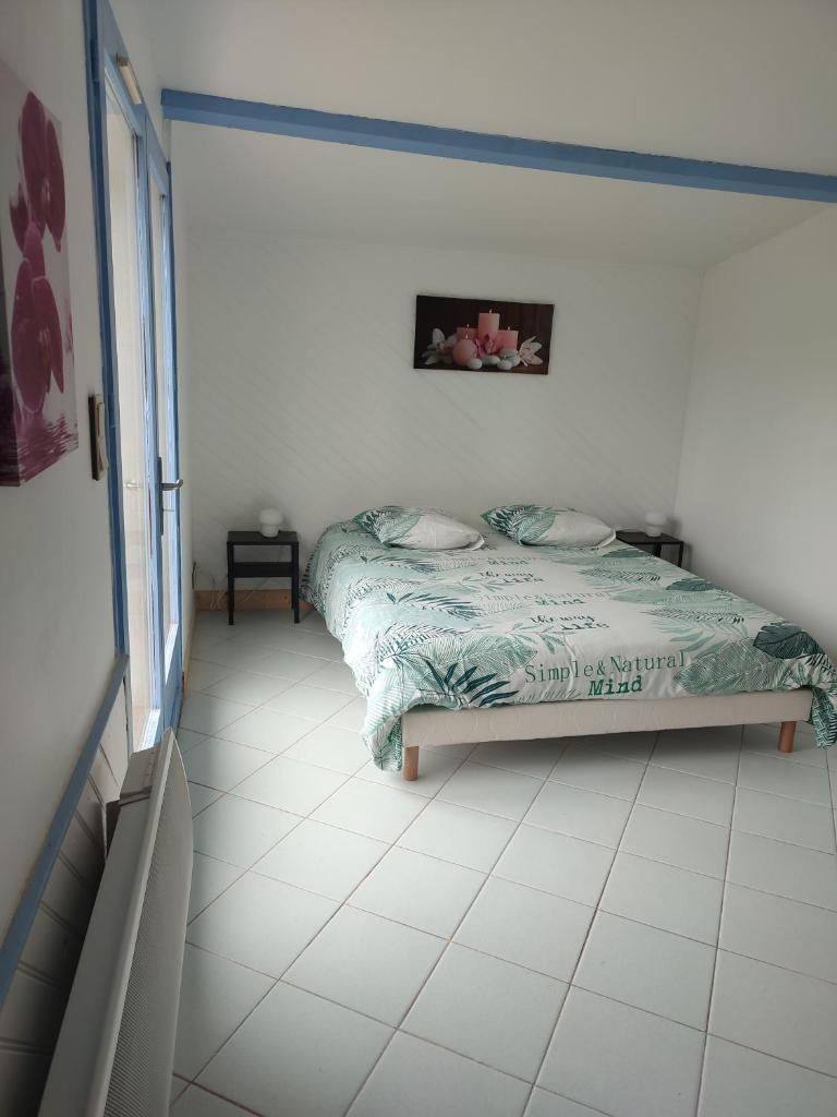 une chambre avec un lit et un sol carrelé dans l'établissement Le gîte du moulin de Pontalaman, à Lafrançaise 1 autre photo