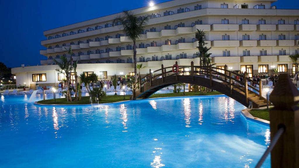 un pont au-dessus d'une piscine devant un immeuble dans l'établissement Hotel Roscianum Welness SPA, à Rossano