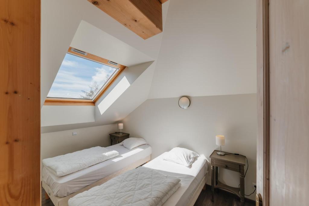 deux lits dans une petite pièce avec une fenêtre dans l'établissement Résidence Sunêlia Les Logis d'Orres, aux Orres