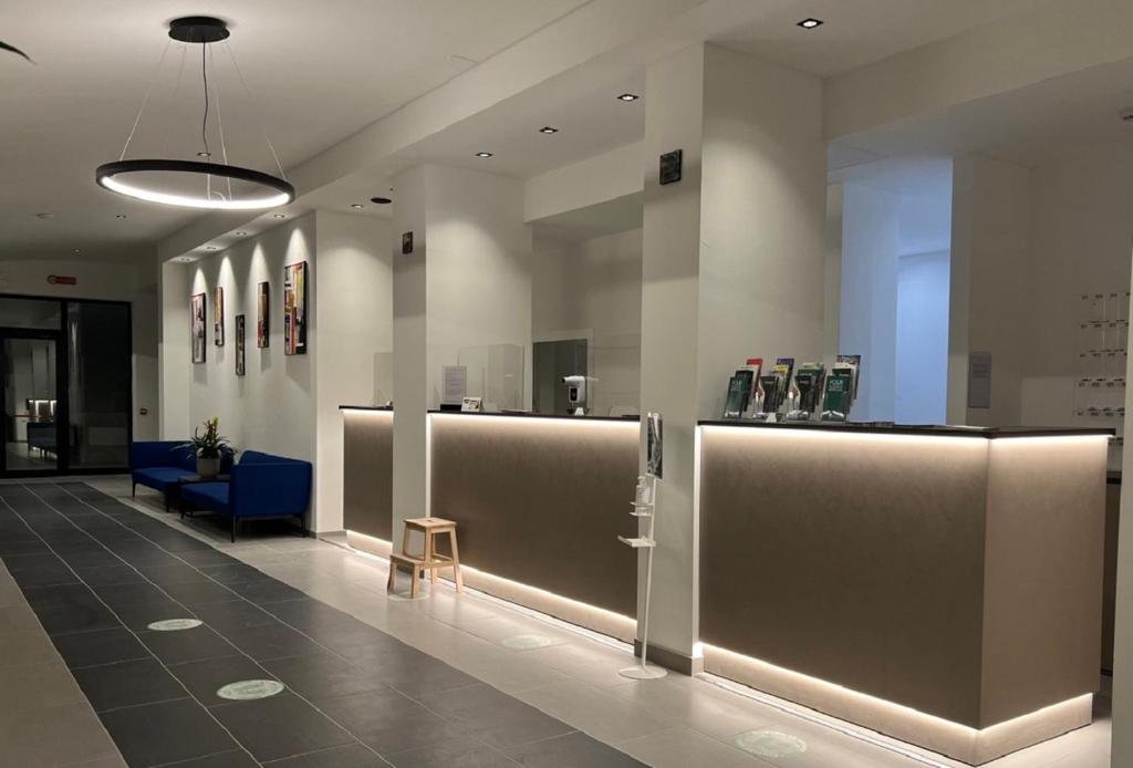 un hall d'un immeuble avec une chaise bleue et une table dans l'établissement Hotel Palazzo Caveja, à Rimini