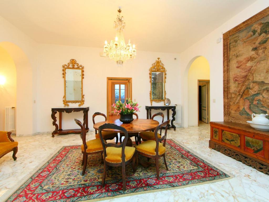 une salle à manger avec une table, des chaises et un lustre dans l'établissement Villa Poggio Patrignone-1 by Interhome, à Campoluci 30 autres photos