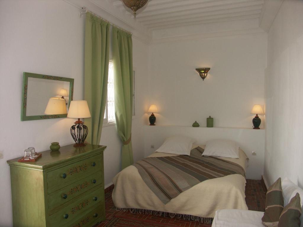 une chambre avec un lit, une commode et une fenêtre dans l'établissement Dar Ness, à Essaouira