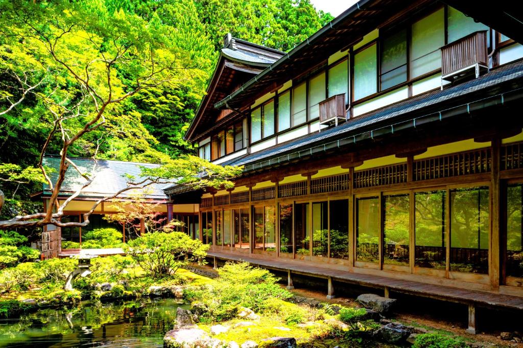 un bâtiment avec un étang en face d'un jardin dans l'établissement 高野山 宿坊 龍泉院 -Koyasan Shukubo Ryusenin-, à Koyasan