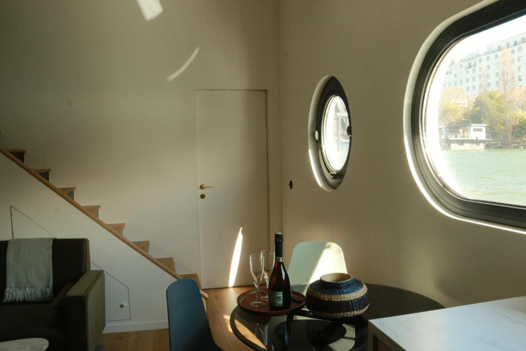 une pièce avec une table et une horloge au mur dans l'établissement Studio très cosy - indépendant dans une péniche - Paris 16, à Puteaux
