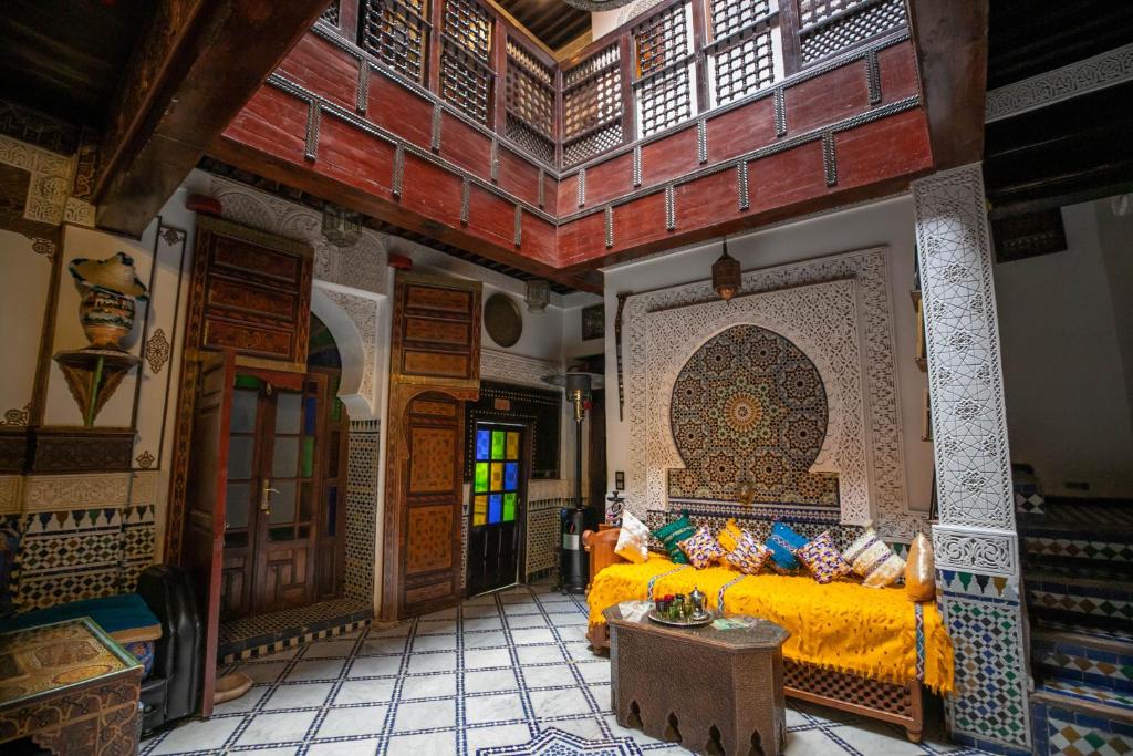 - une chambre avec un lit jaune dans une pièce avec un mur dans l'établissement Dar El Yasmine, à Fès