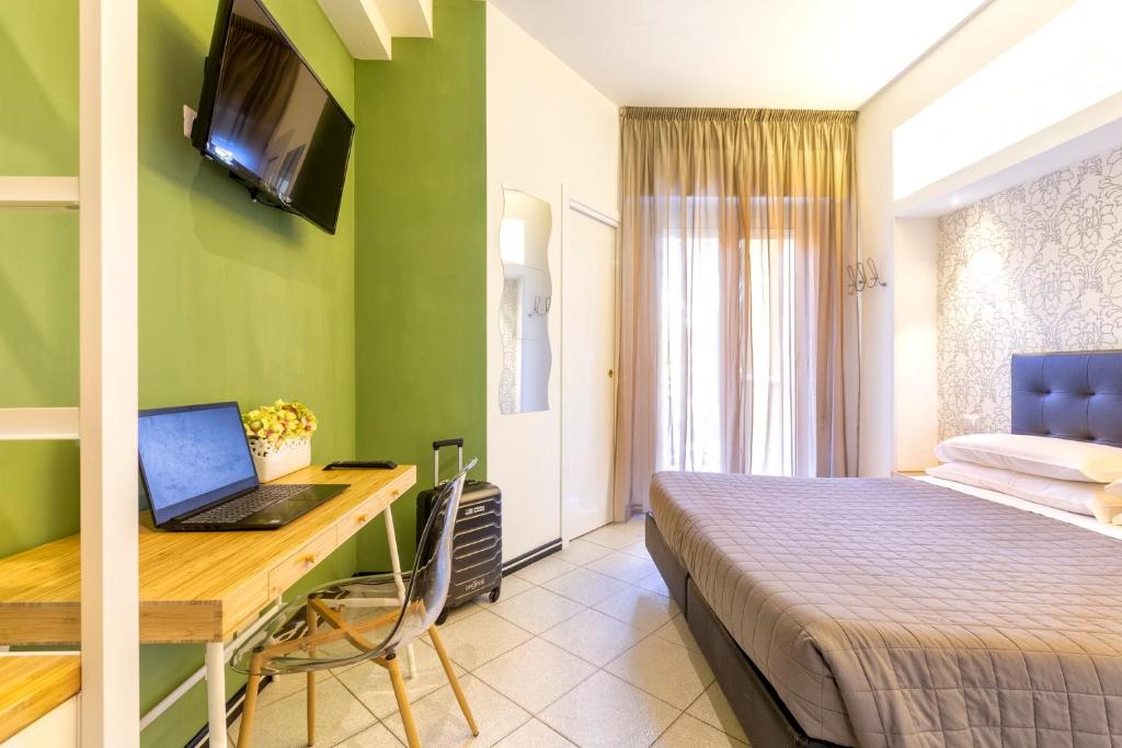 une chambre avec un lit et un bureau avec un ordinateur portable dans l'établissement Hotel La Nidiola, à Riccione