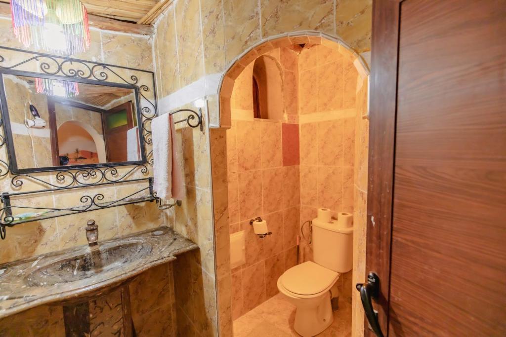 une salle de bain avec toilettes, lavabo et miroir dans l'établissement Riad Mamouche, à Merzouga 37 autres photos