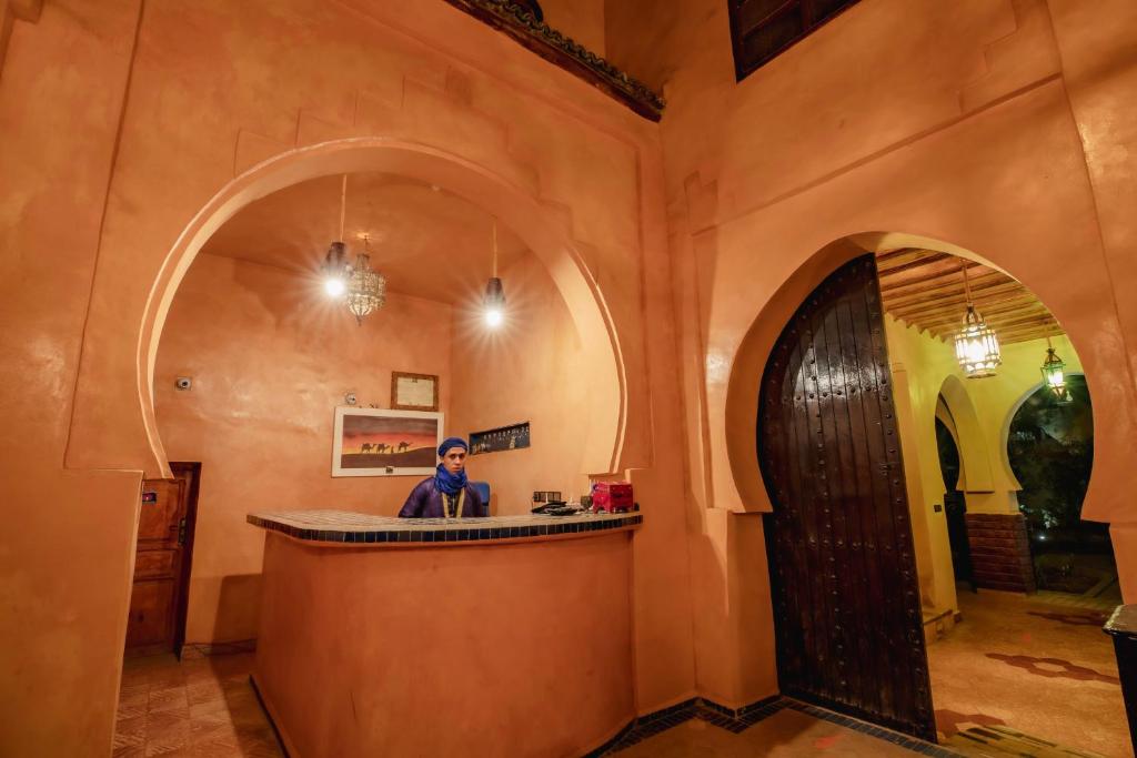 un homme assis au bar dans une pièce dans l'établissement Riad Mamouche, à Merzouga