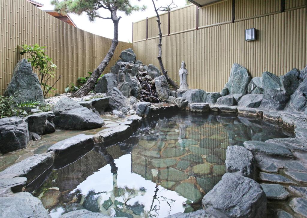 un étang dans un jardin avec des rochers dans l'établissement Awaji International Hotel The Sunplaza, à Sumoto 37 autres photos