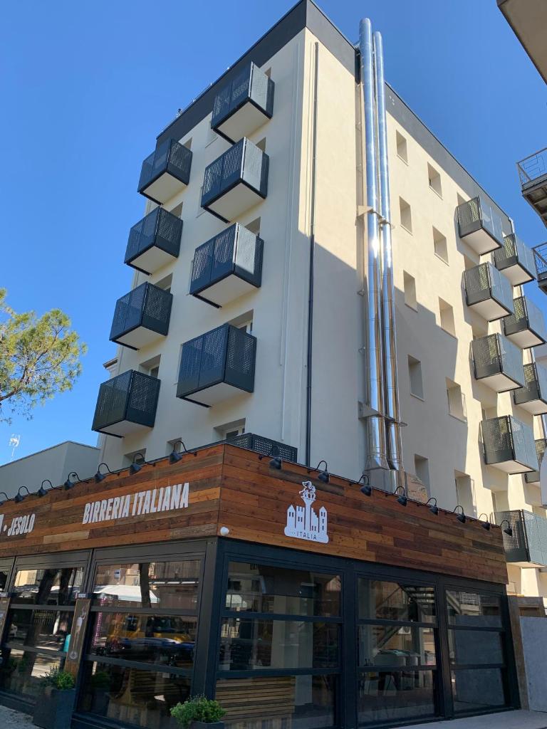 un hôtel avec un bâtiment en arrière-plan dans l'établissement Superior Beach Aparthotel, à Lido di Jesolo