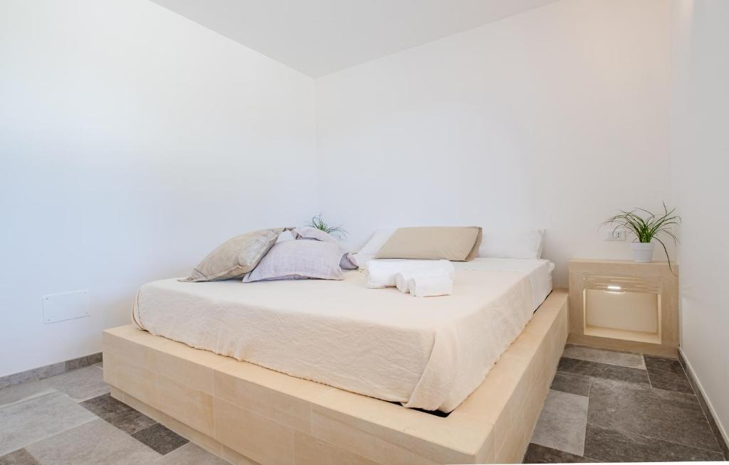 Ce lit se trouve dans un dortoir doté d'un mur blanc. dans l'établissement Villa Li Tratturi Luxury by HDSalento, à Corsano