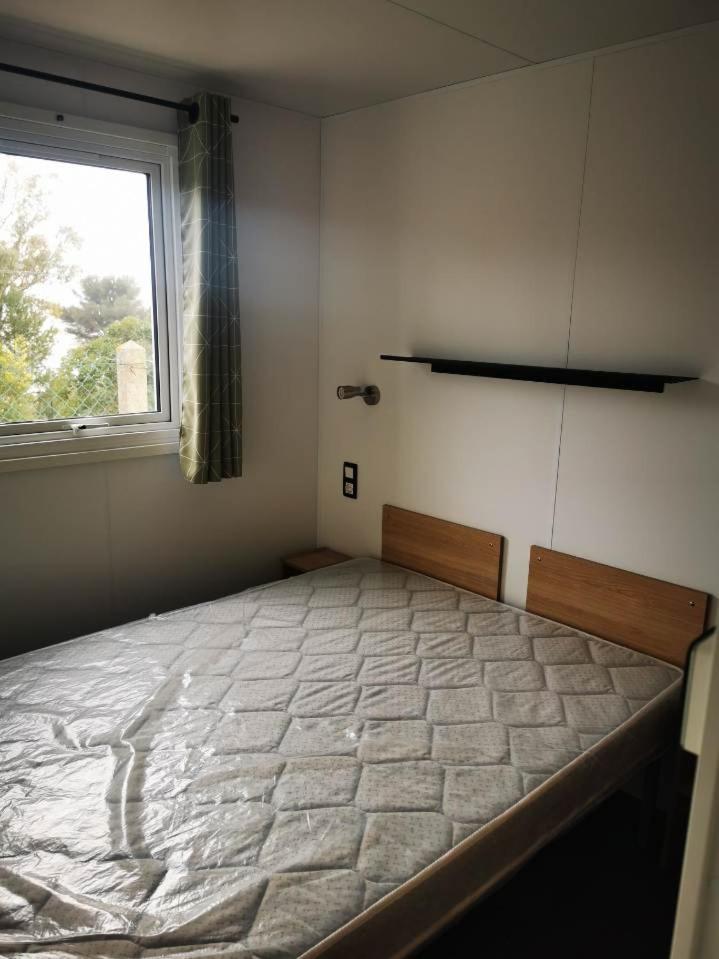 une chambre avec un grand lit avec une fenêtre dans l'établissement Mobil home 8 personnes camping l ile d or saint raphael, à Saint-Raphaël 31 autres photos
