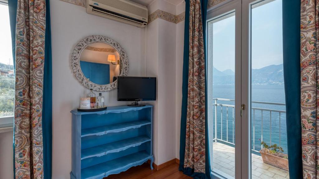 Cette chambre dispose d'une fenêtre offrant une vue sur l'océan. dans l'établissement La Caletta Hotel Bolognese, à Brenzone
