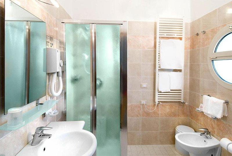 une salle de bain avec douche, lavabo et toilettes dans l'établissement Hotel Bristol - Koolibry Hotels, à Cervia 61 autres photos