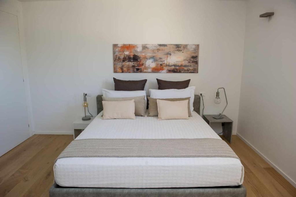 une chambre avec un grand lit blanc avec des oreillers dans l'établissement Villa Via Bolgherese, à Bibbona