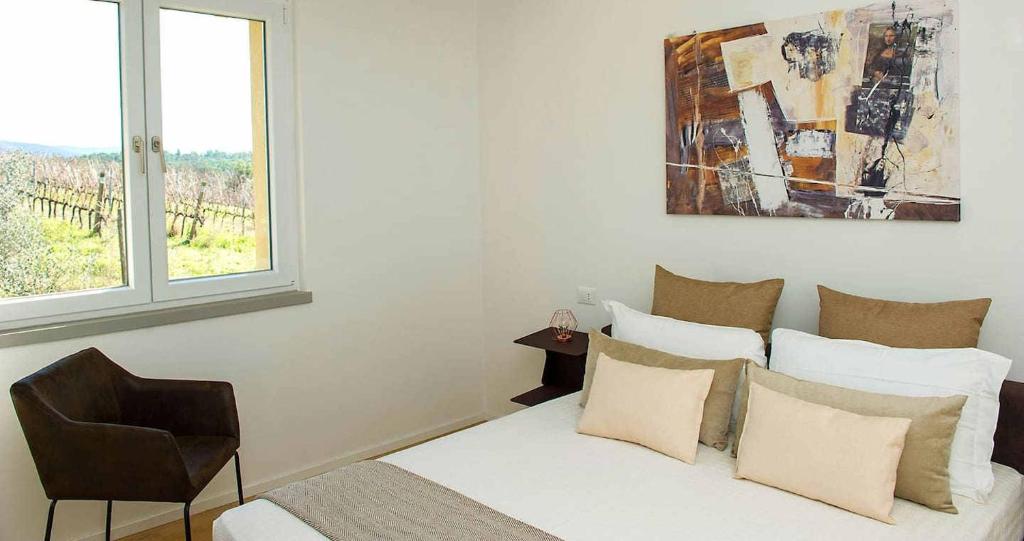 une chambre avec un lit avec une chaise et une fenêtre dans l'établissement Villa Via Bolgherese, à Bibbona 38 autres photos