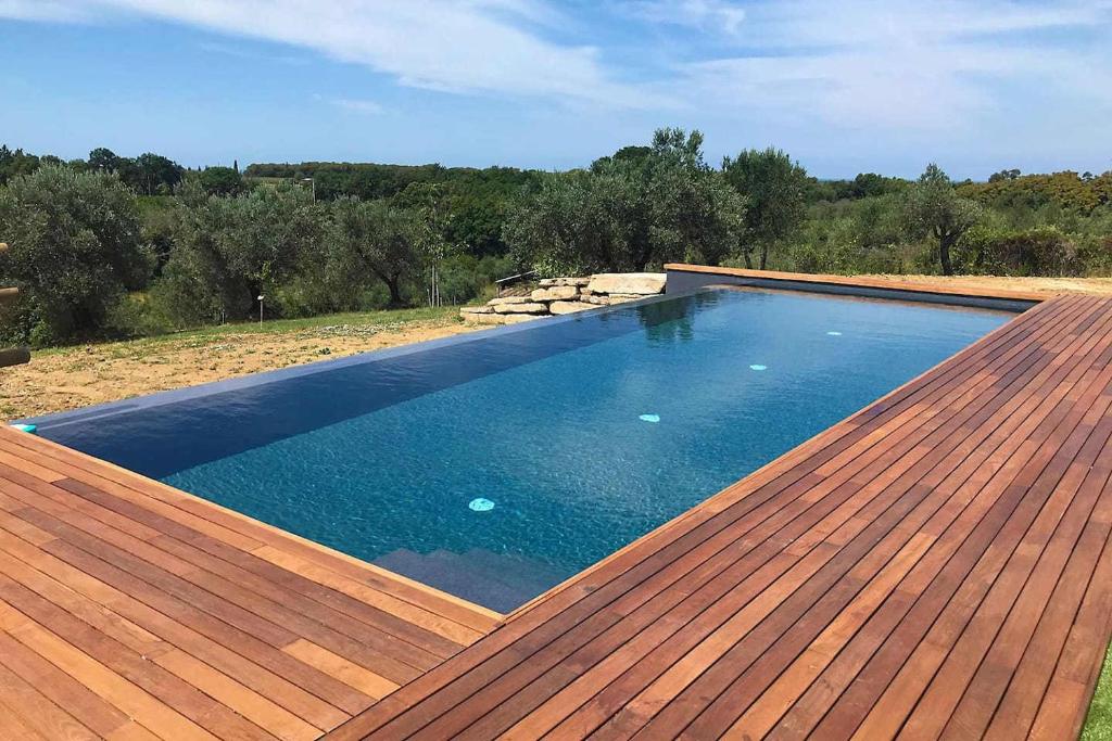 - une piscine sur le toit avec une terrasse en bois dans l'établissement Villa Via Bolgherese, à Bibbona
