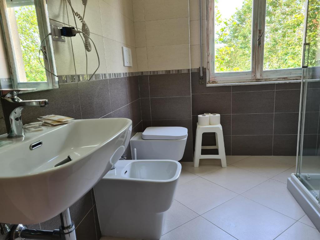 une salle de bain avec un lavabo, des toilettes et un miroir dans l'établissement NEW PARK HOTEL, à Lido di Camaiore