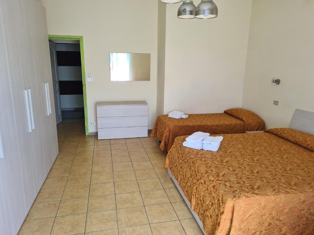 une chambre d'hôtel avec deux lits et un sol carrelé dans l'établissement NEW PARK HOTEL, à Lido di Camaiore