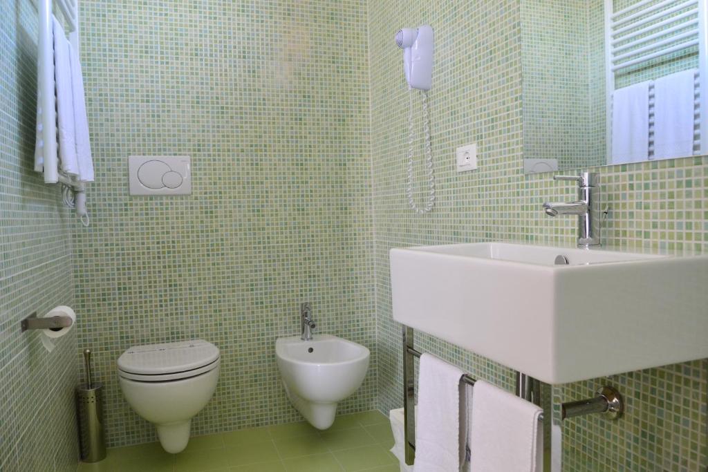 une salle de bain avec toilettes et lavabo dans l'établissement Hotel Morena, à Lido di Jesolo 67 autres photos