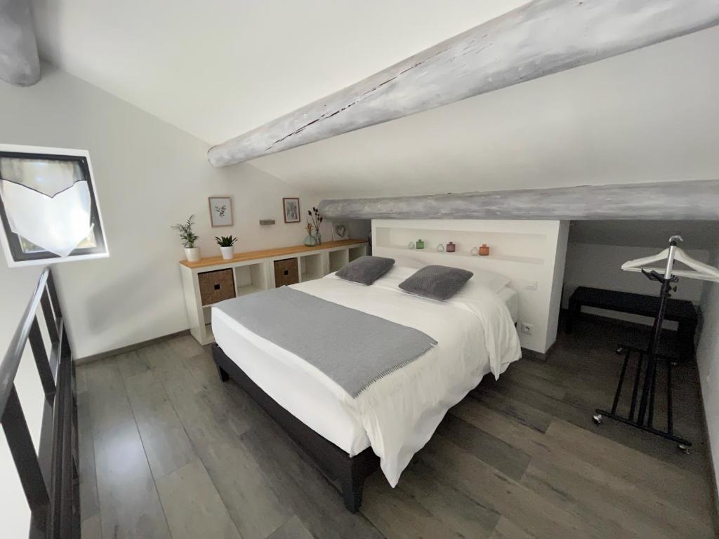 une chambre avec un grand lit blanc et un bureau dans l'établissement Gîtes dans Mas en pierres, à Robion