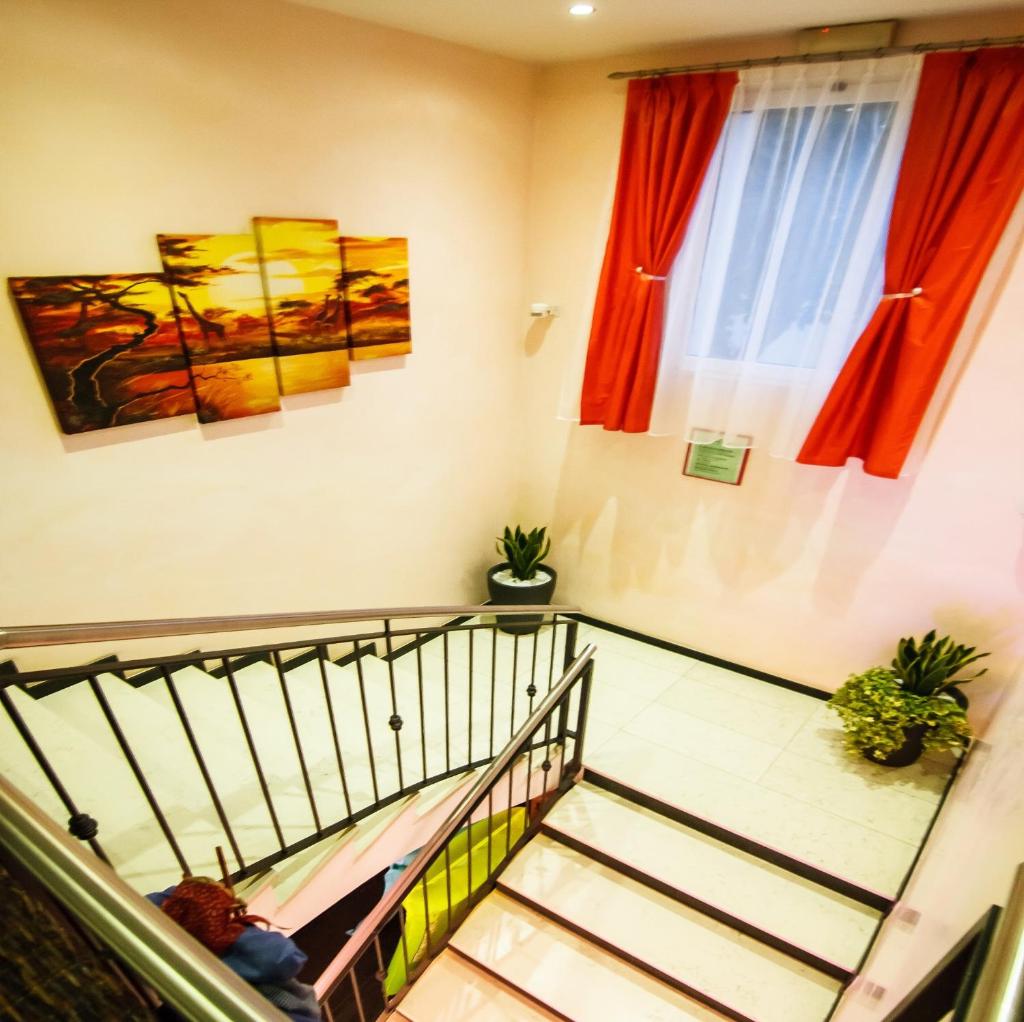 un escalier dans un bâtiment avec des peintures sur les murs dans l'établissement Hotel Savoia, à Lignano Sabbiadoro