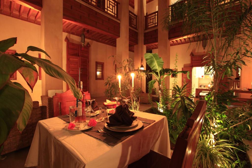 - une table à manger dans une pièce ornée de plantes dans l'établissement Riad Al Ksar & Spa, à Marrakech