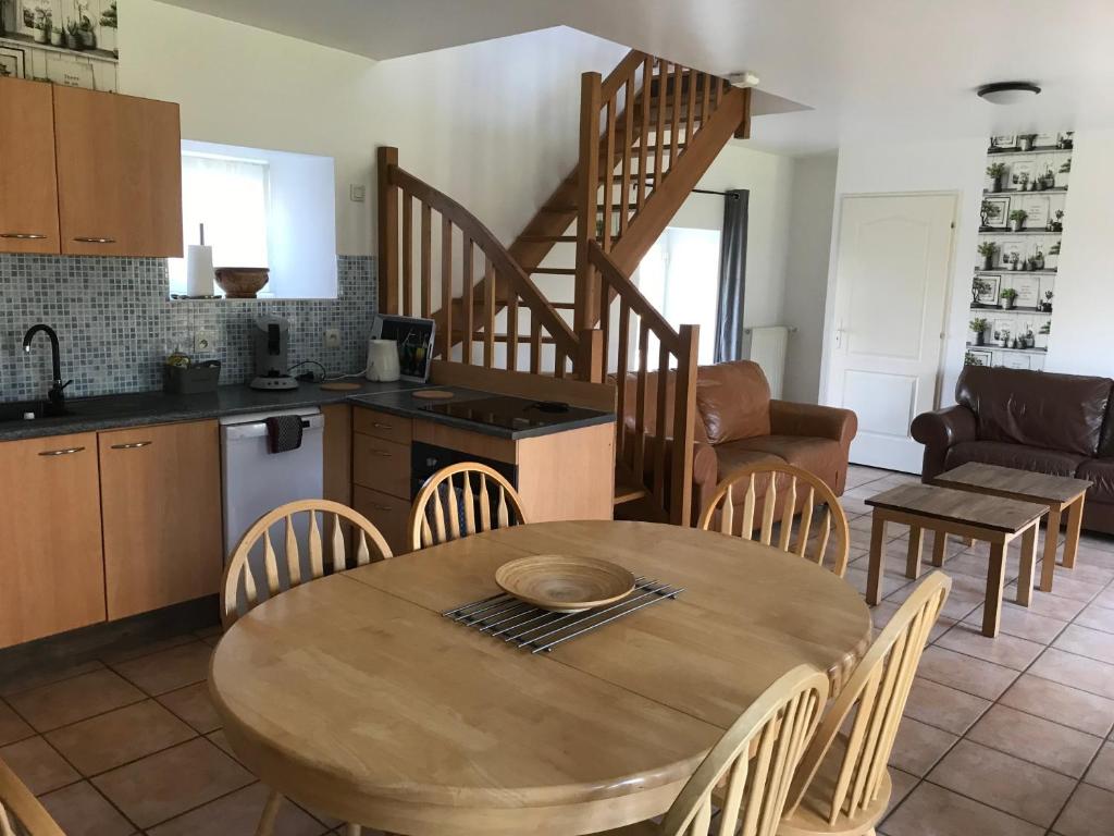 une cuisine et une salle à manger avec une table et des chaises dans l'établissement Gites de Kermoel, Belle Île, à Kernascléden
