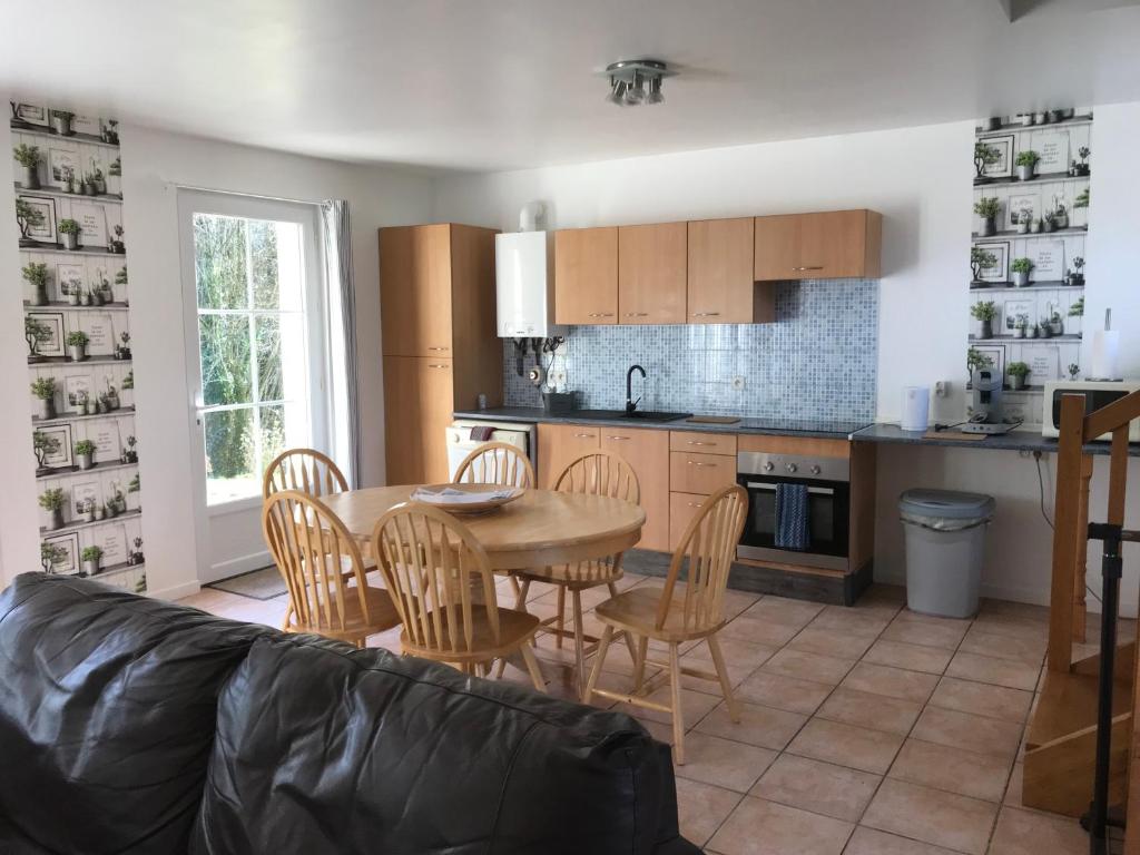 une cuisine et une salle à manger avec une table et des chaises dans l'établissement Gites de kermoel, Ouessant, à Kernascléden