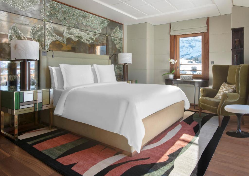 une chambre avec un grand lit blanc et une chaise dans l'établissement Four Seasons Hotel Megeve, à Megève